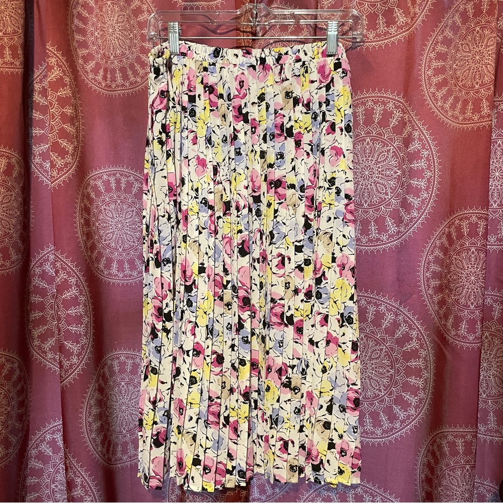 Mid calf length pleated skirt with blue, yellow, pinkpurple, and brown flowers.